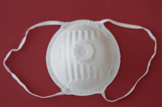 White COVID-19 face mask against red background